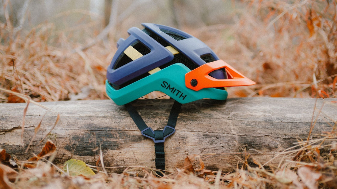 A multicolor Forefront 3 helmet resting on a log. 
