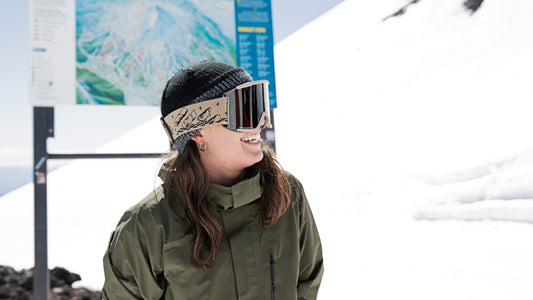 Professional skier Taylor Lundquist wearing Smith goggles and snow gear on a mountain smiling. 