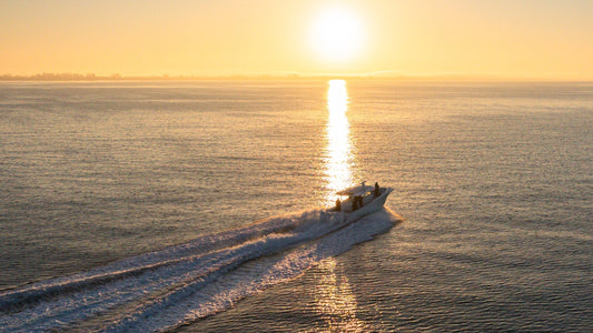 Sunrise image of a fishing boat moving across the water