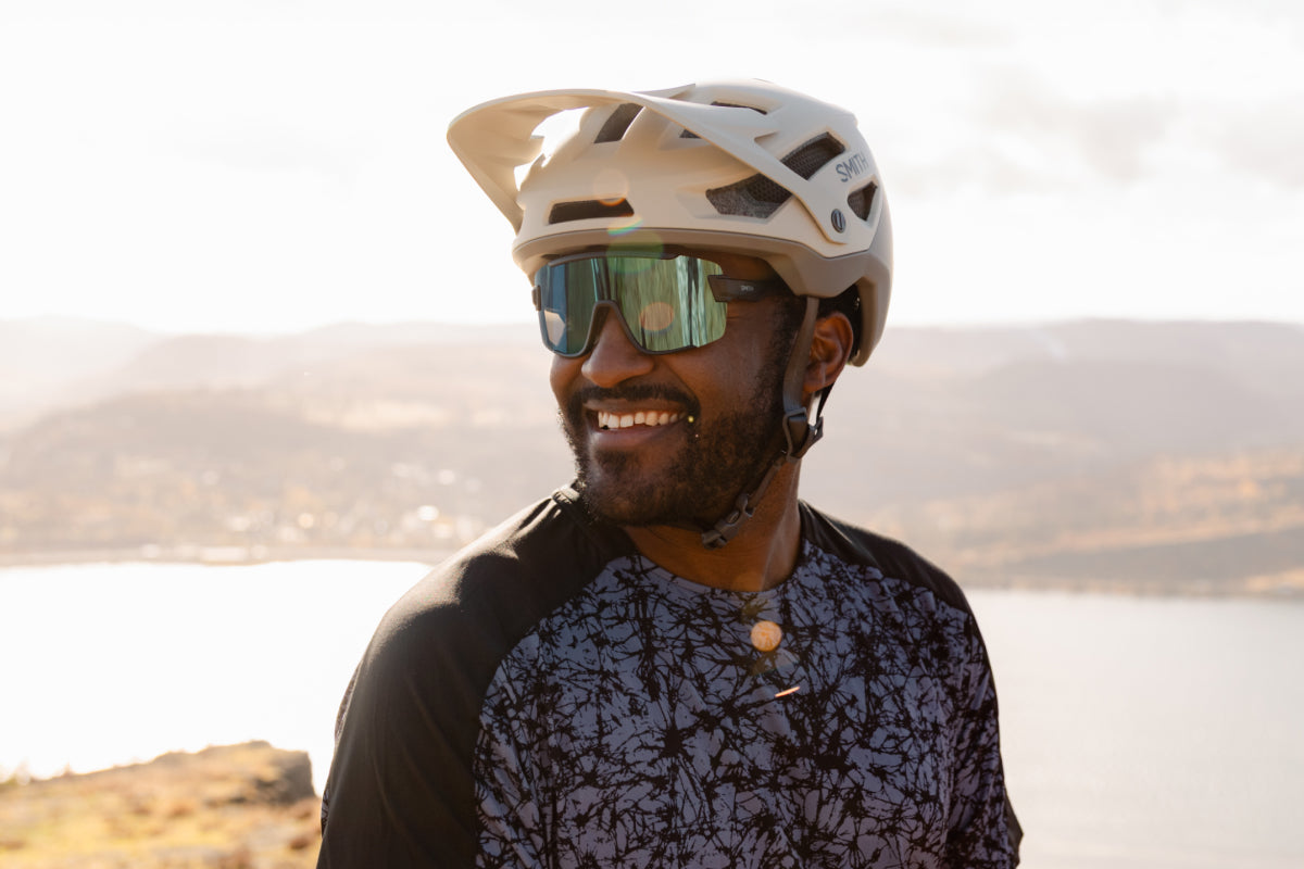 Man wearing the Smith Wildcat sunglasses and helmet with a scenic background