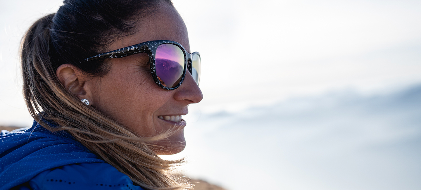 Woman on mountain ridge having okay day wearing sunglasses