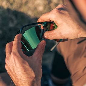 Man adjusting changing lens on the Motive Sunglasses