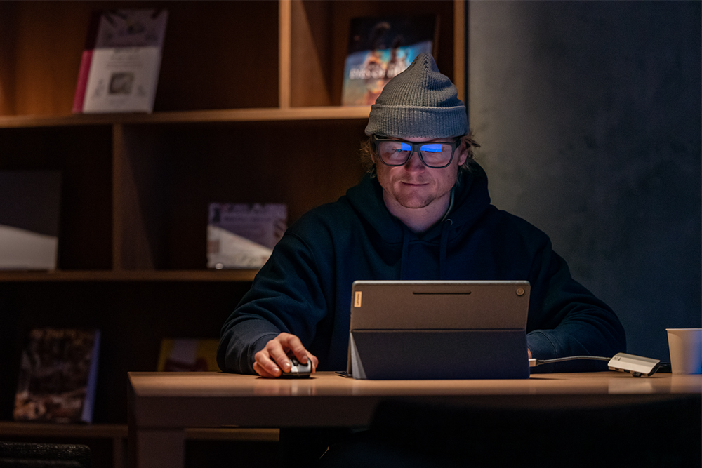 Man wearing blue light glasses working at a computer